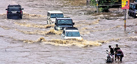 Commuters move through a waterlogged road after heavy rainfall in Bikaner  
