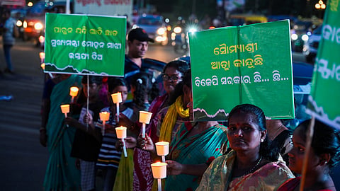 Political workers and people stage a human chain holding candles while demanding justice for FM Autonomous College self-immolation victim in Odisha.