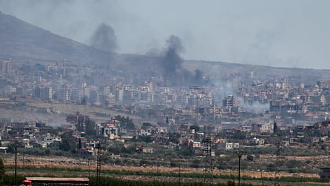 Smoke rises from clashes between Syrian government forces and Druze militias in Sweida city, southern Syria, Tuesday, July 15, 2025.