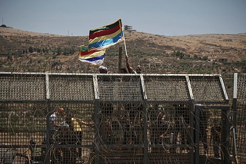 Syrian Druze protest near the Israeli-Syrian border, as seen from the town of Majdal Shams in the Israeli-controlled Golan Heights, Wednesday, July 16, 2025, amid the ongoing clashes between Syrian government forces and Druze armed groups in the southern Syrian city of Sweida. 