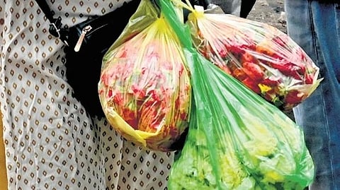A woman uses plastic bags to carry floweres in Bengaluru 
