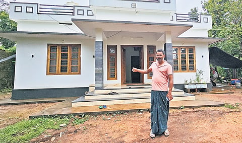 Abdul Salam in front of his newly built house at Chooralmala 