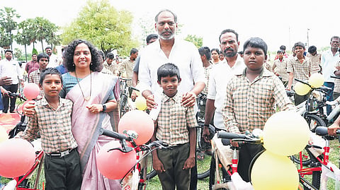 Energy Minister Gottipati Ravi Kumar distributing bicycles to government school students in Addanki constituency of Bapatla district on Tuesday. 