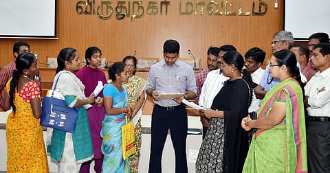  Virudhunagar District Collector N O Sukhaputhra is receiving petitions from widows and destitute women at a special grievance redressal meeting.