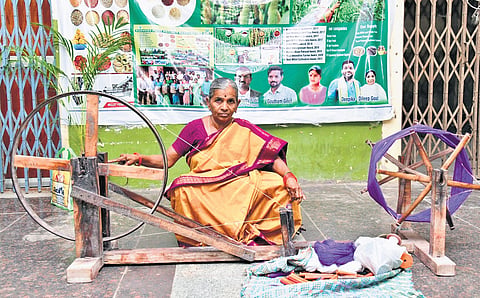 A weaver from Telangana showcases a ‘charkha’ at the Karimnagar collectorate on National Handloom Day, celebrated on Thursday.