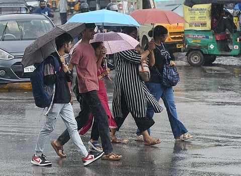  Students were seen reaching their destinations in drizzle  while protecting themselves with umbrella in Hyderabad