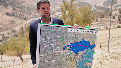 Israeli Finance Minister Bezalel Smotrich holds a map that shows the E1 settlement project during a press conference near the settlement of Maale Adumim, in the Israeli-occupied West Bank, Thursday, Aug. 14, 2025. 