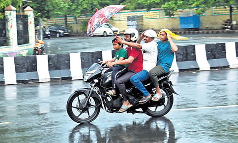 Commuters riding through rain in Visakhapatnam on Tuesday 