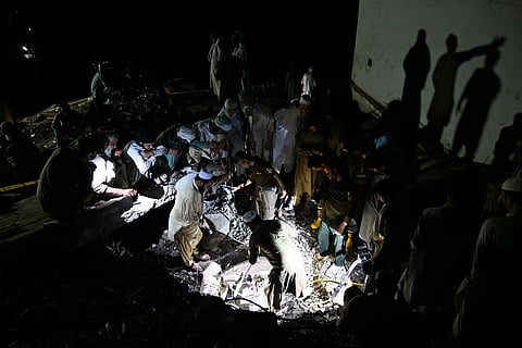 Rescue workers and residents search for victims in the debris of collapsed houses after a cloudburst in Dolari village, Swabi district, in northern Pakistan's mountainous Khyber Pakhtunkhwa province, on August 18, 2025. 