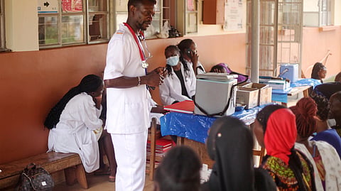 A health worker talks to patients at Wakiso Health Centre IV in Kampala