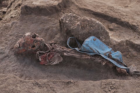 An exhumed human skeleton is seen with a school bag at the site of a mass grave in Chemmani, Sri Lanka, June 28, 2025.