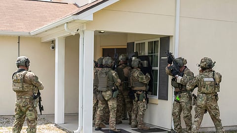 Immigration and Customs Enforcement (ICE) Special Response Team members demonstrate how the team enters a residence in the pursuit of a wanted subject at the Federal Law Enforcement Training Centers (FLETC) in Brunswick, Ga. on Thursday, Aug. 21, 2025.