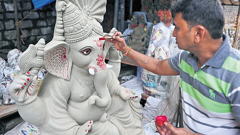 A vendor gives final touches to clay idols of Lord Ganesha, imported from Kolkata, which are available for sale at Banjara Hills on Thursday 