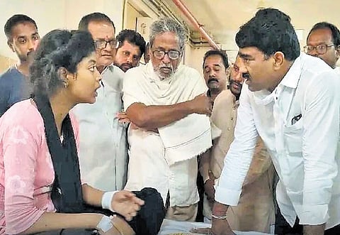 Srikakulam MLA Gondu Sankar consoles Divya, daughter of the deceased couple, at RIMS. 