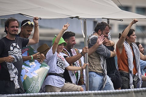 Swedish climate activist Greta Thunberg waves from a boat taking part in a civilian flotilla bound for Gaza, aiming to break the Israeli blockade and deliver humanitarian aid, in Barcelona, Spain, Sunday, Aug 31, 2025.