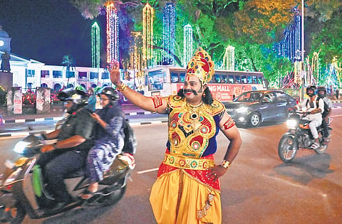 A person dressed up as King Mahabali walking past the illuminated Secretariat as part of the tourism department’s Onam celebrations 
