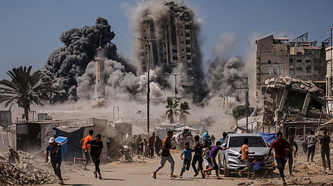 Palestinians run for cover during an Israeli airstrike on a high-rise building in Gaza City, Friday, Sept. 5, 2025, after the Israeli army issued a prior warning. 
