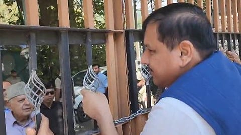 In a video shared by MP Sanjay Singh, he is seen climbing the gates and demanding to speak with the police.