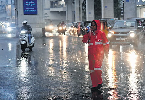 A female cop regulates traffic as amid rains in Hyderabad.