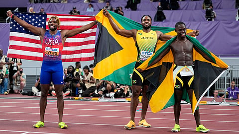 Jamaica's gold medalist Oblique Seville, right, and silver medalist Kishane Thompson, pose with bronze medalist United States' Noah Lyles, left, after competing in the men's 100 meters final at the World Athletics Championships in Tokyo, Sunday, Sept. 14, 2025. 