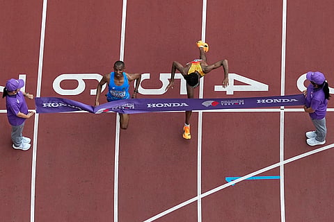 Tanzania's Alphonce Felix Simbu, left, crosses the finish line ahead of Germany's Amanal Petros to win the men's marathon at the World Athletics Championships in Tokyo, Monday, Sept. 15, 2025. 