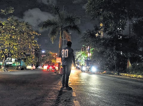 A commuter tries to cross the ill-lit Stadium Link Road, one of the localities in the city where streetlights are not functional 