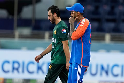 India's captain Suryakumar Yadav, right, and Pakistan's captain Salman Agha walk onto the field before the start of the Asia Cup cricket match between India and Pakistan at Dubai International Cricket Stadium in Dubai, United Arab Emirates, Sunday, Sept. 14, 2025.