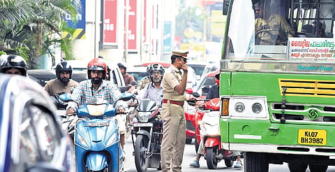 A police officer manually managing traffic flow at Kaloor Junction.