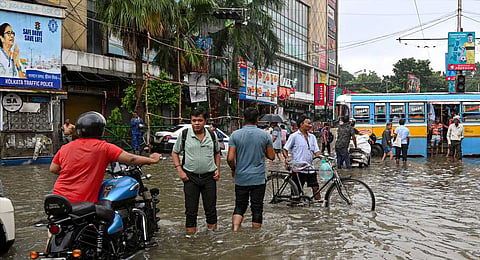 Commuters make their way through a waterlogged road following rain, in Kolkata, Tuesday, Sept. 23, 2025. 