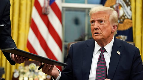 US President Donald Trump signs executive orders in the Oval Office of the White House, in Washington.