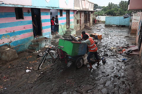 GHMC workers clean the waste near the houses at flood affected Musi nagar near Chaderghat bridge in November, 2026.