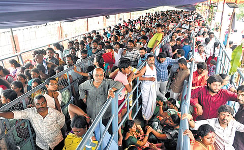 Devotees wait in queue lines to take darshan of goddess Kanaka Durga in Sri Maha Chandi Devi avatar during day seven of Dussehra festivities atop Indrakeladri hill in Vijayawada on Sunday. 