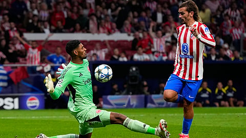 Atletico Madrid's Antoine Griezmann and Frankfurt's goalkeeper Kaua Santos challenge for the ball during the Champions League opening phase soccer match between Atletico Madrid and Eintracht Frankfurt on Sept. 30, 2025. 