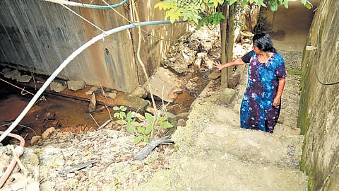 62-year-old Thressiama climbing the makeshift concrete steps built by the contractor connecting their home to the national highway in Chirangara on the Thrissur-Edappally stretch.  