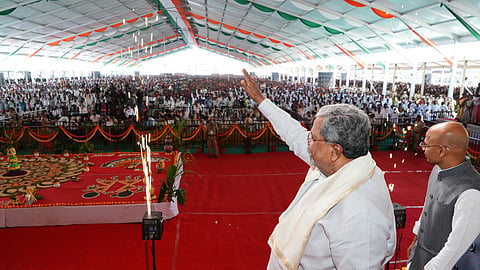 Chief Minister Siddaramaiah waves to supporters in Koppal on Monday. Minister Dr Sharan Prakash Patil is also seen.