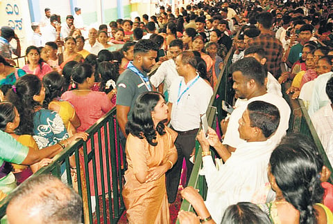 Hassan Deputy Commissioner KS Latha Kumari interacts with devotees standing in queue at Hasanamba Temple in Hassan on Monday 