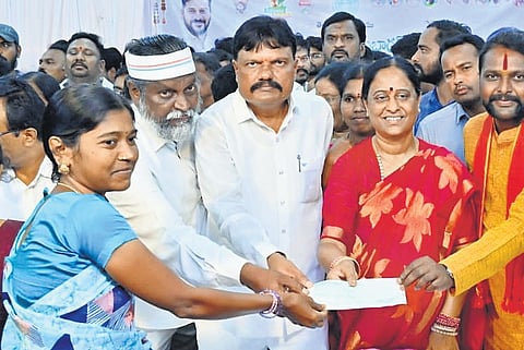Endowments Minister Konda Surekha hands over cheques to beneficiaries  of various schemes in Warangal on Tuesday