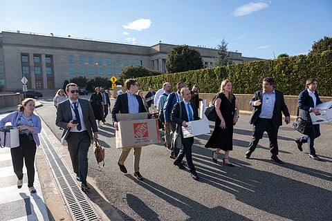 Members of the Pentagon press corp carry their belongings out of the Pentagon after turning in their press credentials, Wednesday, Oct. 15, 2025 in Washington. 