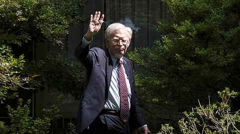 Former US National Security Adviser John Bolton waves as he arrives at his house Aug. 22, 2025, in Bethesda, Md. 