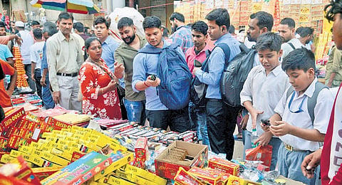 Stalls across the area, particularly near Gate No. 2 of the Red Fort Metro station, are stacked with brightly labelled boxes reading “Pollution Free,” “Go Green,” and “Big Sound, Less Smoke.” 