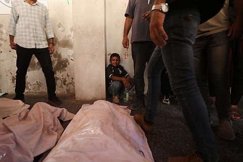 Mourners gather around the bodies of Palestinians, killed by Israeli fire after crossing the ceasefire line according to the Hamas-run Civil Defense, as they brought to Al Ahli Hospital in Gaza City, Saturday, Oct. 18, 2025. 