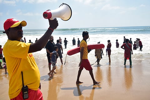 Life guards urge visitors not to venture too deep into the sea in view of 'Cyclone Montha', in Puri, Sunday, Oct. 26, 2025.