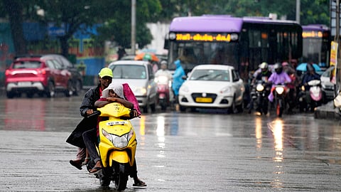 Commuters make their way through rain triggered by Cyclone Montha, in Chennai, Tamil Nadu, Monday, Oct. 27, 2025