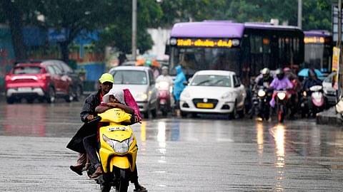 Commuters make their way through rain in Chennai, Tamil Nadu, Monday, Oct. 27, 2025. 