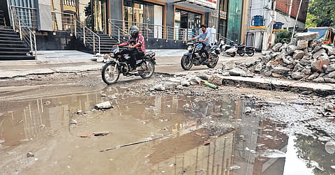 Motorists negotiate a damaged  road in Pragathi Nagar, Yousufguda, which falls under the  Jubilee Hills Assembly constituency in Hyderabad.