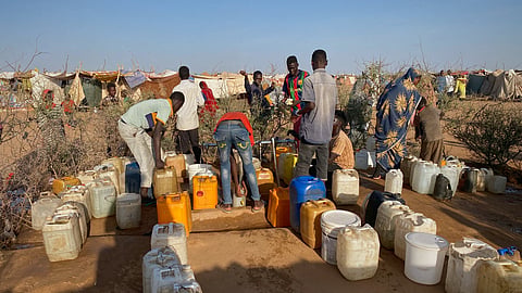 Sudanese men who fled el-Fasher city, after Sudan's paramilitary forces killed hundreds of people in the western Darfur region, collect water at a camp in Tawila, Sudan, Saturday, Nov. 1, 2025. 