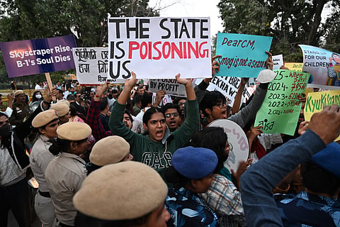 Demonstrators hold posters and shout slogans during a protest demanding the government take action to reduce air pollution in New Delhi on November 9, 2025.