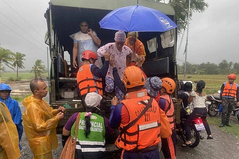 In this photo provided by the Philippine Coast Guard, rescuers evacuate residents in Sablayan, Occidental Mindoro province of the Philippines as Typhoon Fung-wong batters the country on Sunday, Nov. 9 2025.