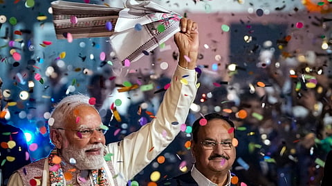 Prime Minister Narendra Modi waves a 'gamcha' as he arrives during the celebration of NDA's victory in the Bihar Assembly elections, at BJP headquarters, in New Delhi, Friday, Nov. 14, 2025. 