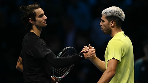 Spain's Carlos Alcaraz shakes hands with Italy's Lorenzo Musetti after winning the match at the ATP Finals tennis tournament in Turin on November 13, 2025.